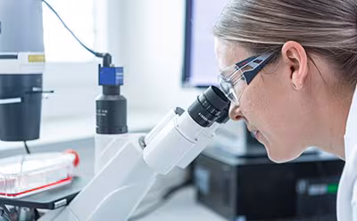 mRNA Operator looking into a microscope